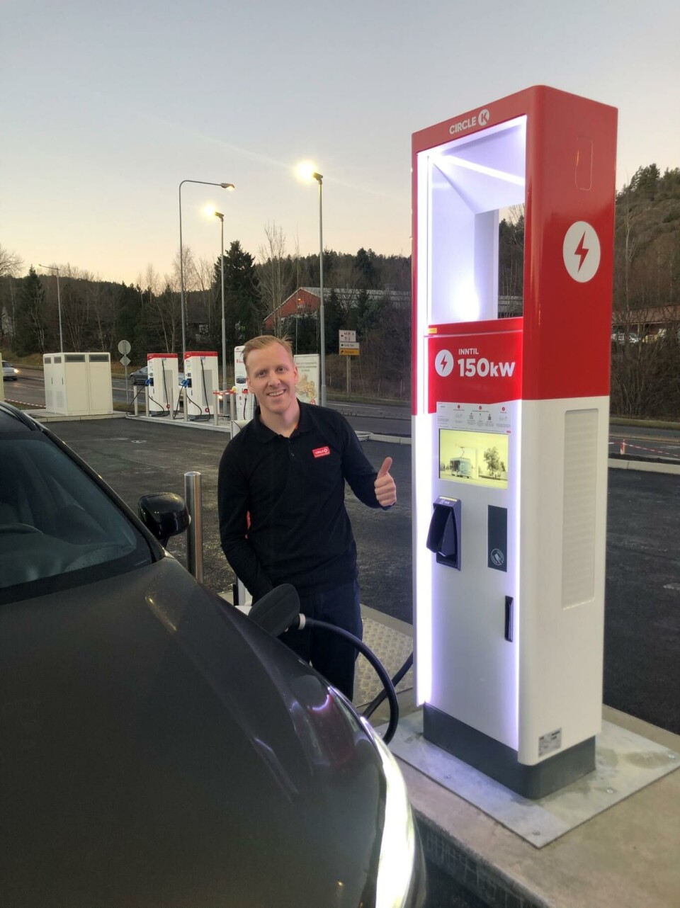 LADER OPP. Daglig leder Even Øygarden ved Circle K Telemarksporten gir tommel opp til de nye laderne som er installert på stasjonen hans. Foto: Circle K Telemarksporten